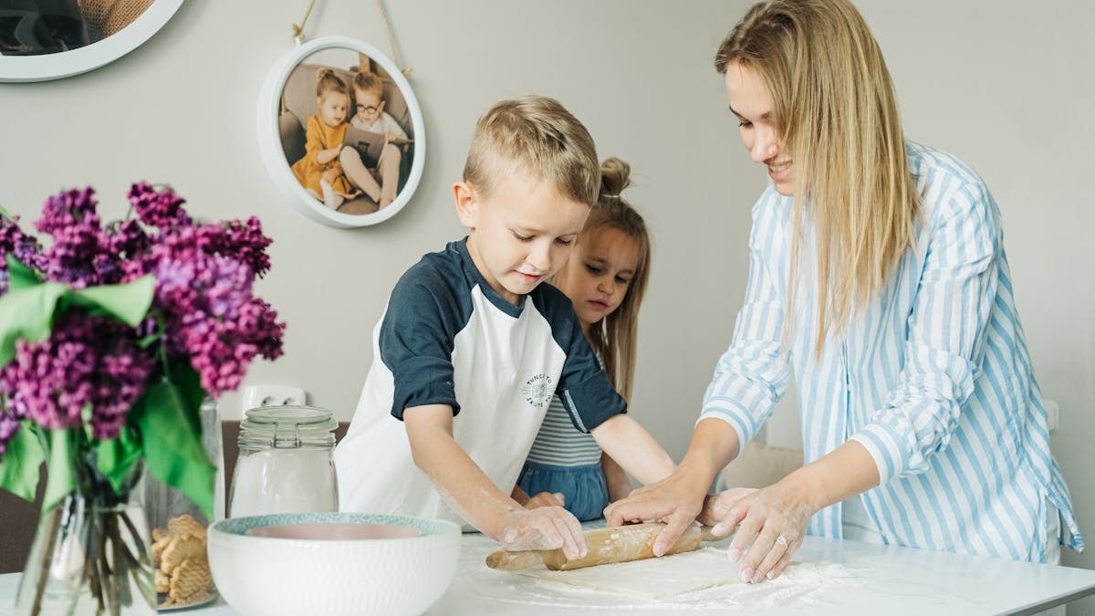Mother and children enjoying a fun and messy baking session together at home.