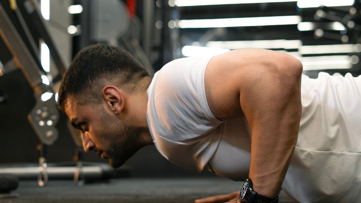 Man doing push-ups in a gym.